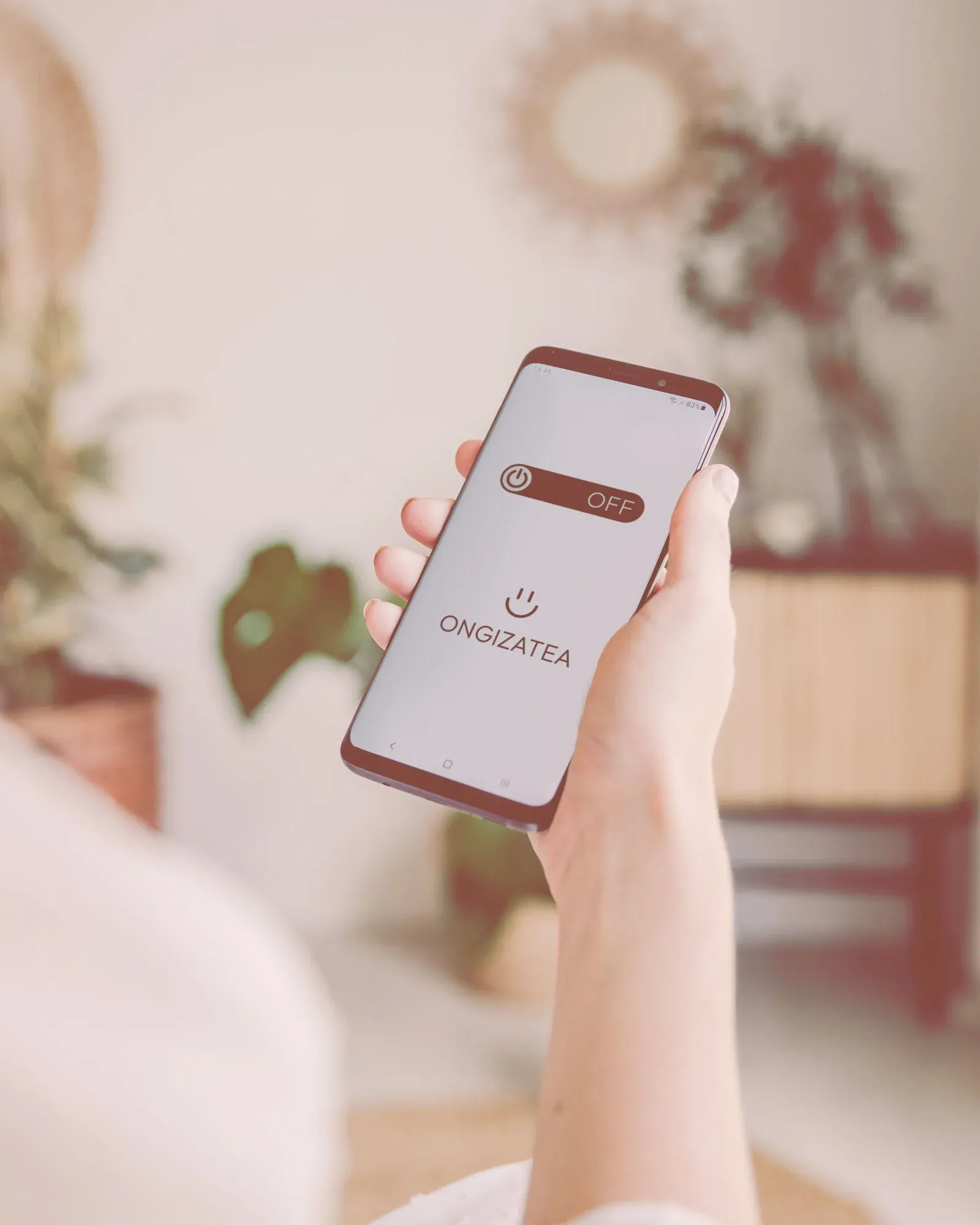 Persona sosteniendo un smartphone con la aplicación de bienestar digital Ongizatea para desconexión y salud mental
