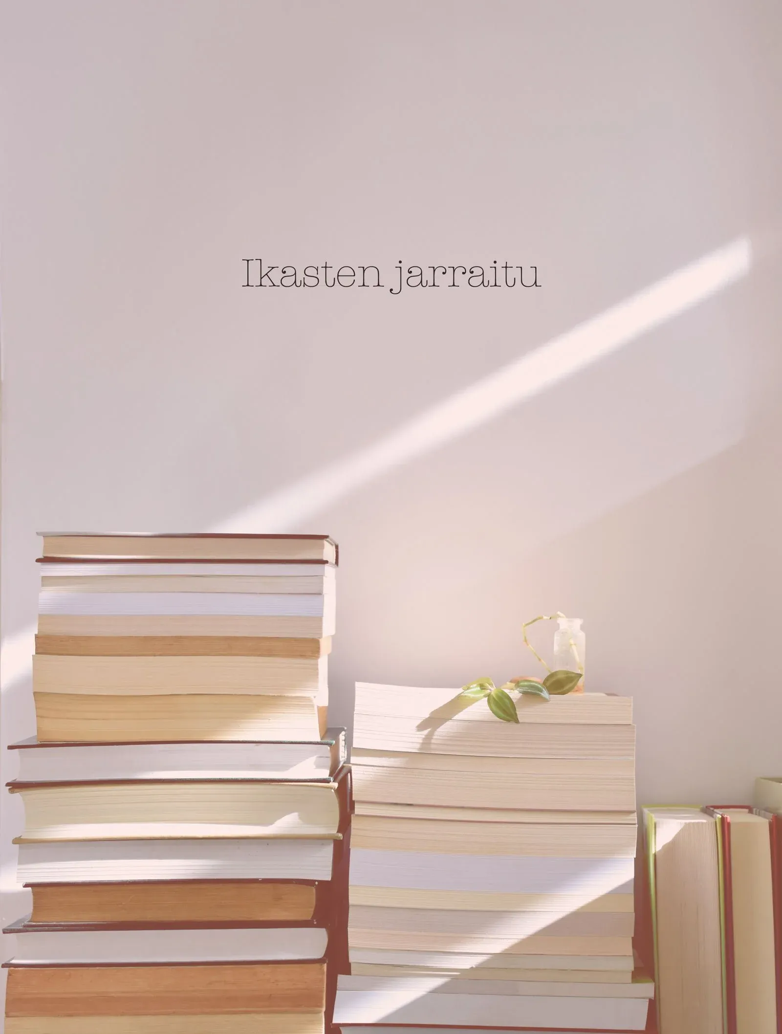 Pila de libros con luz natural y el texto Ikasten jarraitu, concepto de aprendizaje continuo y bienestar emocional